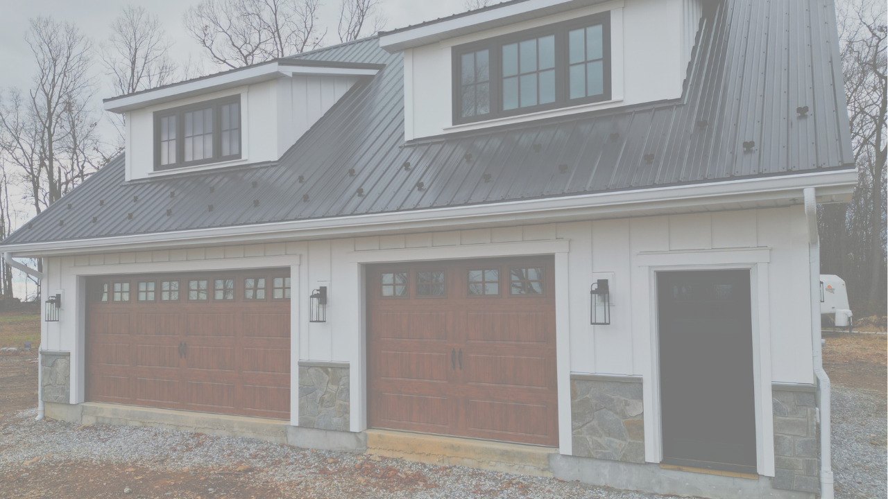 Exterior of Garage Apartment House featuring 1 double garage door, 1 single garage door and an entry door. The garage doors are woodgrain and the siding is white board and batten with a black roof.